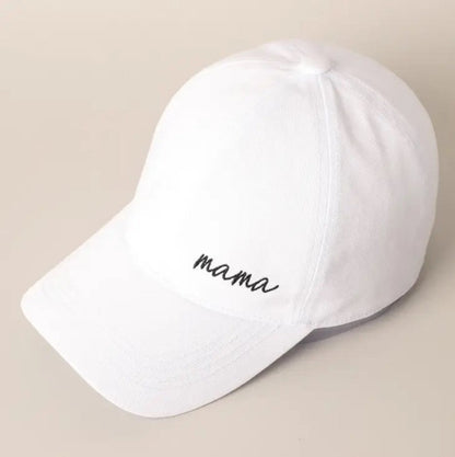 White black mama cursive embroidered baseball hat sitting angled on a creme background.