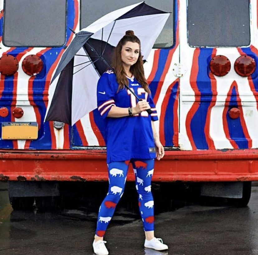 woman wearing royal blue, red, and white buffalo print silky soft leggings holding umbrella. 